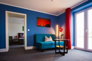 a blue room with a blue couch and a table at Appartements am Rindhof in Münnerstadt