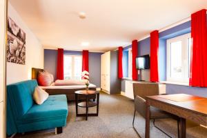 ein Wohnzimmer mit roten Vorhängen und einem blauen Sofa in der Unterkunft Appartements am Rindhof in Münnerstadt
