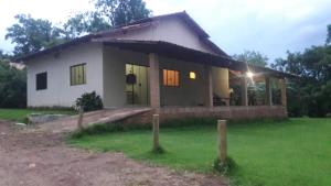 uma pequena casa branca com um jardim verde em Casa Da Lua em Pirenópolis