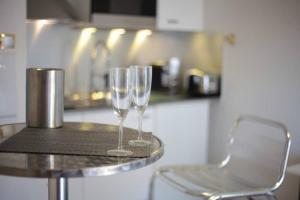 - deux verres à vin assis sur une table dans une cuisine dans l'établissement Appartement avec Balcon Immeuble Standing, à Lyon