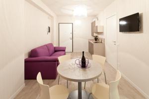 a living room with a table and a purple couch at Residence Lenno in Lenno
