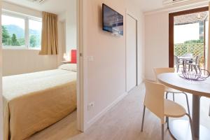 a bedroom with a bed and a table and chairs at Residence Lenno in Lenno