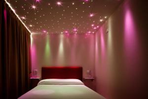 a bedroom with a bed with pink lights on it at Residence Lenno in Lenno