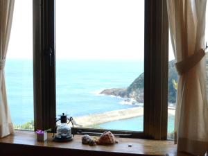 a window with a view of the ocean at Gardenvilla Shirahama in Shimoda