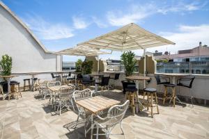 
a patio area with tables, chairs and umbrellas at Room Mate Anna in Barcelona
