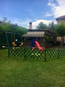 a fence with a playground in front of a house at Alisachni in Paralia Panteleimonos