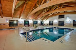 a swimming pool in a building with an indoor pool at Staybridge Suites Middleton/Madison-West, an IHG Hotel in Middleton