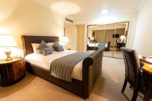 a hotel room with a bed and a desk and a bedroom at Britannia Country House Hotel & Spa in Manchester