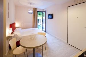 a room with a bed and a table and chairs at Residence Lenno in Lenno