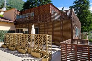 a house with a wooden fence and a umbrella at Residence Lenno in Lenno