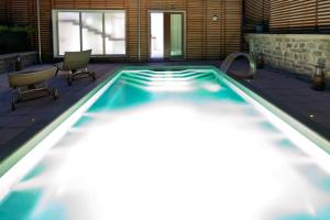 a swimming pool with two chairs and a table at Residence Lenno in Lenno