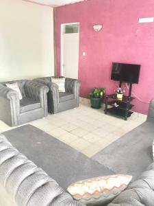 - un salon avec deux canapés et une télévision à écran plat dans l'établissement Bandari apartment, à Mombasa