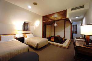 a hotel room with two beds and a mirror at Gardenvilla Shirahama in Shimoda