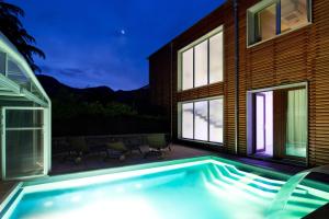 a swimming pool in front of a house at Residence Lenno in Lenno