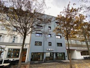 ein weißes Gebäude mit einem braunen Schild darauf in der Unterkunft BLOOM Boutique Hotel & Lounge Basel in Basel