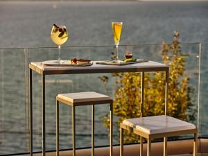 
a table topped with a glass of wine and a plate of food at Ionian Hill Hotel in Argassi
