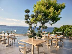 a patio with tables and chairs and the ocean at Ionian Hill Hotel in Argassi