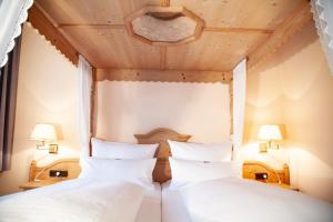 2 Betten in einem Schlafzimmer mit Holzdecke in der Unterkunft Hotel Lonac in Duisburg
