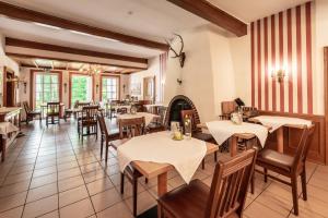 a restaurant with tables and chairs and a fireplace at Hotel Hof Tütsberg in Behringen