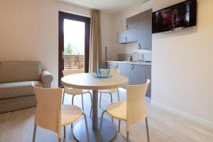 a kitchen and living room with a table and chairs at Residence Lenno in Lenno