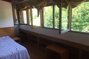 a bedroom with a bed and three windows at Casa Vacanze Almades in Almàdis