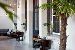 a dining room with a table and a palm tree at Hotel Mariënhage in Eindhoven