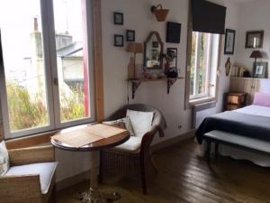 1 dormitorio con 1 cama, 1 mesa y 1 silla en Les chambres du Chat Perché en Le Havre