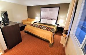 a small hotel room with a bed and a television at Super 8 by Wyndham Monticello in Monticello