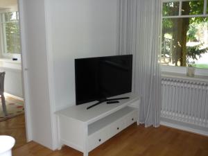 a living room with a tv on a white cabinet at Ferienwohnung Elke Eggers in Wallsbüll