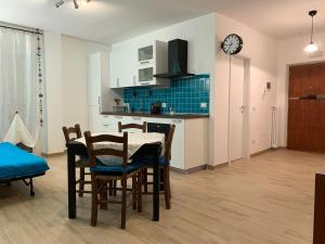 Una cocina y un comedor con mesa y sillas. en Casa Turchese, en Merano