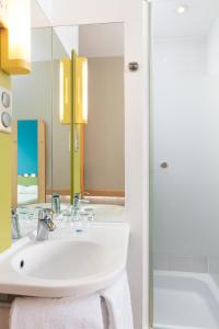 a bathroom with a white sink and a mirror at ibis budget Warszawa Centrum in Warsaw