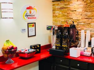 a counter with a red counter top with some food on it at Super 8 by Wyndham Monticello in Monticello