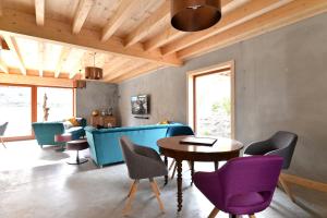 a living room with a blue couch and purple chairs at Les Granges Modernes in Bruebach