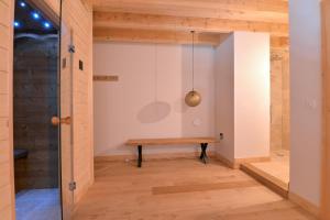 um banco de madeira num quarto com uma parede em Les Granges Modernes em Bruebach
