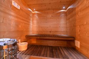 a wooden sauna with a bench and a bucket at Les Granges Modernes in Bruebach