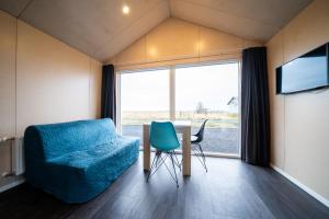 a room with a couch and a table and a large window at Welcome Holiday Home in Eyvindarhólar