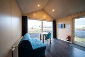 een kamer met een bank, een tafel en een raam bij Welcome Holiday Home in Eyvindarhólar
