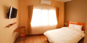 - une chambre avec un lit blanc et une fenêtre dans l'établissement Bluefire Homestay Syariah, à Banyuwangi