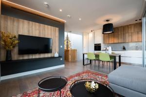 een woonkamer met een bank en een tv bij Mirabilis Apartments - Bayham Place in Londen