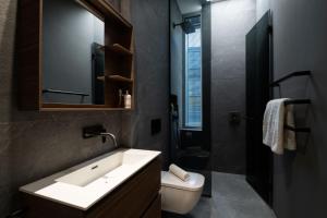 een badkamer met een wastafel, een toilet en een spiegel bij Mirabilis Apartments - Bayham Place in Londen