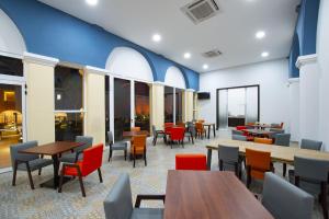 a restaurant with tables and chairs and windows at Holiday Inn Express - Merida Centro, an IHG Hotel in Mérida