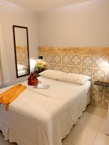 - une chambre avec un grand lit blanc et un miroir dans l'établissement HMG Rio Suítes, à Rio de Janeiro
