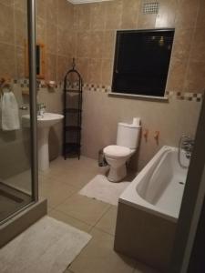 uma casa de banho com uma banheira, um WC e um lavatório. em Rocky Ridge Guest House 2 SELF CATERING - No Alcohol allowed em Roodepoort