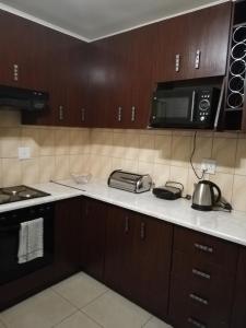 a kitchen with a counter top with a microwave and appliances at Rocky Ridge Guest House 2 SELF CATERING - No Alcohol allowed in Roodepoort