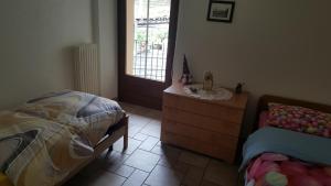 a bedroom with a bed and a dresser and a window at La Tour in Gignod