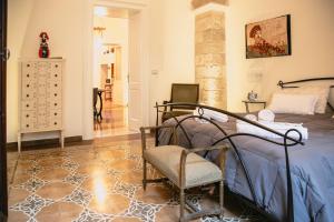 een slaapkamer met een bed en een stoel erin bij Casa di Maya in Lecce