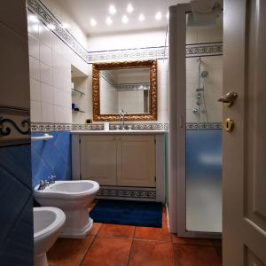 ein Badezimmer mit einem Waschbecken, einem WC und einem Spiegel in der Unterkunft room n.22 suite & apartment in Taranto