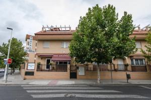 un edificio su una strada con un albero di fronte di Las Abadías a Mérida