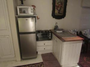 a kitchen with a refrigerator and a microwave on top of it at Marlyn and Dolfyn Self Catering in Paternoster