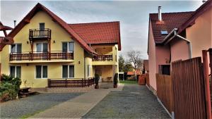 a yellow house with a red roof at Pensiunea Maria Köber in Gura Râului